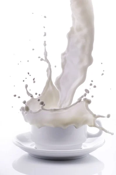 Susu segar dituangkan ke dalam cangkir dengan percikan — Stok Foto