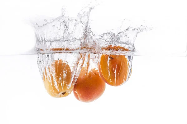 Ein paar Aprikosen ins Wasser tauchen — Stockfoto