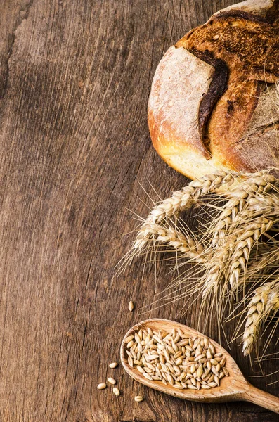 Natura morta Pagnotta di pane con chicchi di grano e farina — Foto Stock