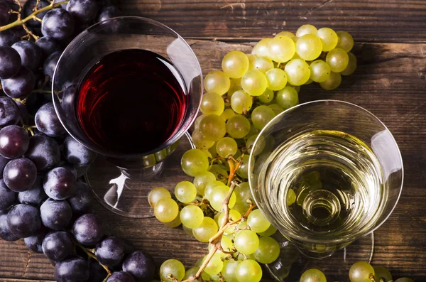 Natura morta. due bicchieri di vino, rosso e bianco con grappoli di g — Foto Stock