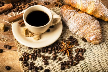 Kahverengi şeker ve kruvasanla tatlandırılmış bir fincan sade kahveyle kahvaltı.