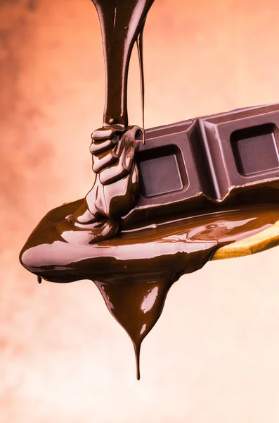 Löffelweise Mit Geschmolzener Dunkler Schokolade Auf Braunem Hintergrund — Stockfoto