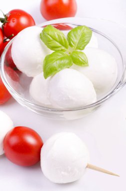 Kiraz domatesli süt ürünleri ve taze fesleğen yaprakları.