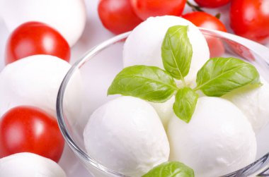 Kiraz domatesli süt ürünleri ve taze fesleğen yaprakları.