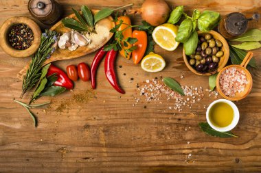 Kırsal ahşap masa, baharat, otlar, zeytinyağı ve biraz sebze ve aksesuar.