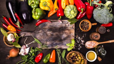 Masadaki farklı sebze ve malzemelerin renkleri ve tatları ve çiğ tahta kesme tahtası.