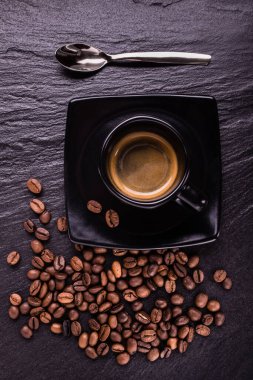 Saf siyah fincanda espresso kahvesi çay kaşığı ve çay kaşığıyla.