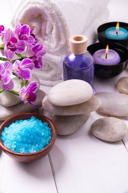 Spa tedavisinin bileşimi. Kavanozda mumlar, su, banyo tuzu ve orkide çiçekleri..