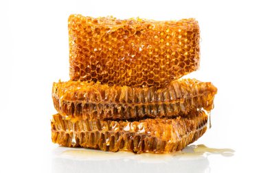 Beyaz arka planda ballı ve balsız bal peteği parçaları.
