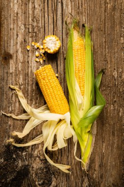 Kaba ahşap masadaki mısır koçanlarının üst görüntüsü. Durgun hayat