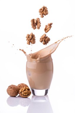 Bardakta, beyaz arkaplandan izole edilmiş, fındıklı bir sebze içeceği.