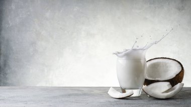 Hindistan cevizinden yapılmış sebze içeceği ve Hindistan cevizinin kırsal gri arka planda kalan kısımları. Metin için boş boşluk