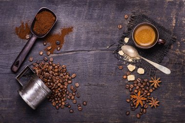 Yukarıdan görüldü. Çiğ ve koyu ahşap masada bir kaşık dolusu kahverengi şeker, kahve çekirdeği ve yıldız anasonlu bir fincan kahve. Boşluğu kopyala