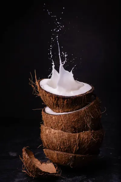 Přední Pohled Některé Části Skládaný Kokos Kokosové Mléko Cákancem Tmavém — Stock fotografie
