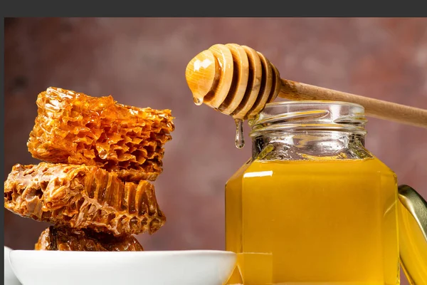 ハニカムとガラスの花瓶アカシアの蜂蜜と蜂蜜が木製のラドルから流れ — ストック写真