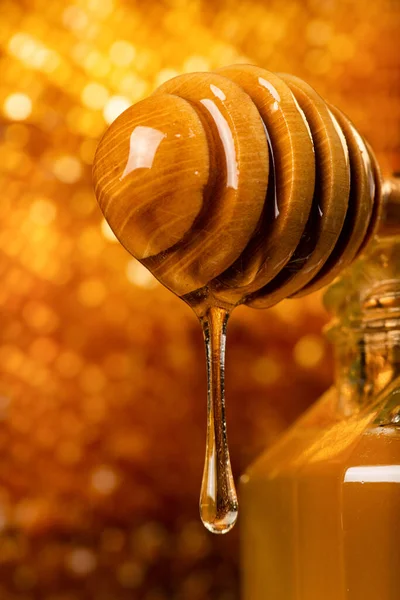前景の木製の柄杓から蜜が静かに流れ — ストック写真