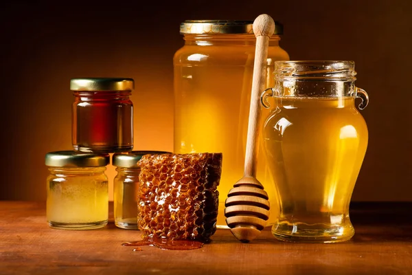 ラドルとハニカムを持つガラス瓶内の蜂蜜の様々なタイプ 静物画 — ストック写真