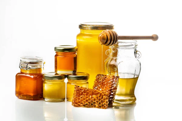 ラドルとハニカムを持つガラス瓶内の蜂蜜の様々なタイプ — ストック写真