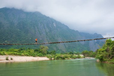 Laos kız lao geleneksel giyim bir tahta köprüden ov gider