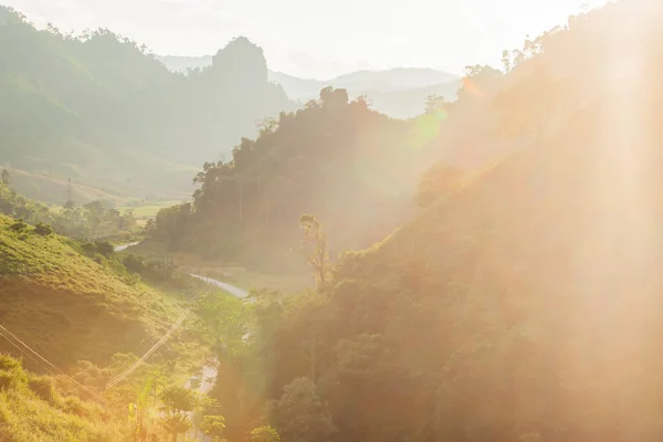 Widok z drogi i góra ze słońcem, idąc w dół. Laos. — Zdjęcie stockowe