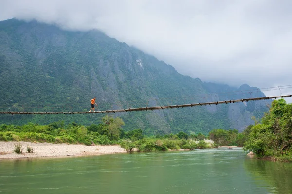 Laos kız lao geleneksel giyim bir tahta köprüden ov gider