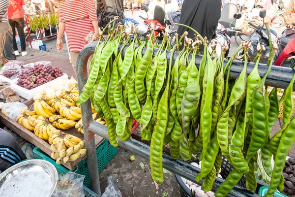 Feijão amargo e várias frutas em um mercado local . — Fotografia de Stock