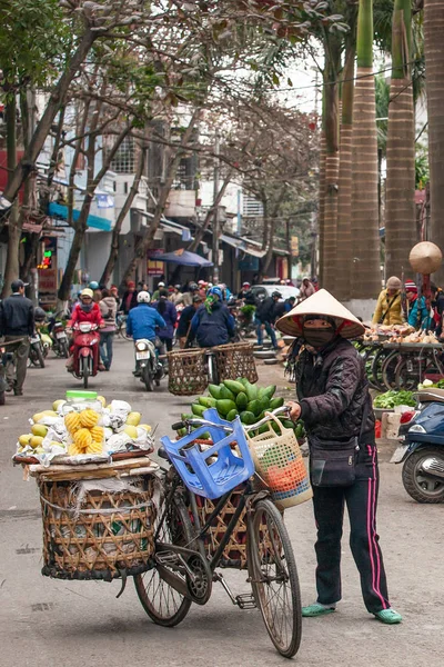 Une vendeuse de rue vietnamienne avec un vieux vélo . — Photo
