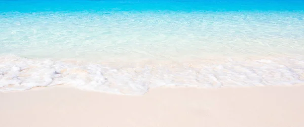 Zachte golven van blauwe oceaan op een zandstrand. — Stockfoto