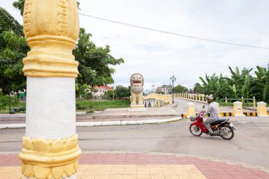Tanımlanamayan Khmer adam sokakta motosiklet sürüyor..