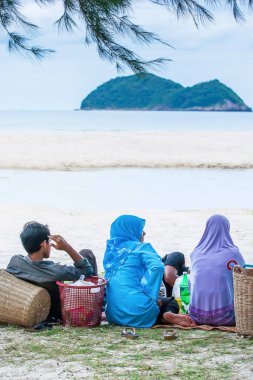 Muslim family picnicking on the beach.