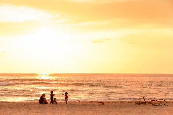 Familia de pescadores tailandeses relajándose en la playa del atardecer . — Foto de Stock