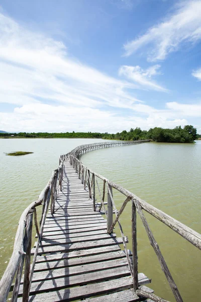Üres fa híd kiterjesztése a zöld sziget a tóban. — Stock Fotó