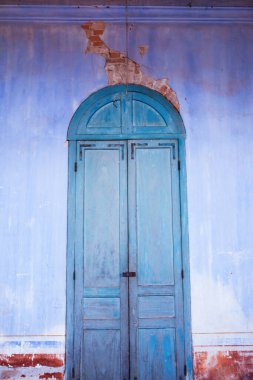 Bulanık arka planlar, güzel eski arktik mavi ahşap kapı ve gök mavisi duvar, antik tuğla duvarda çatlamış beton. Odaklanmayın.