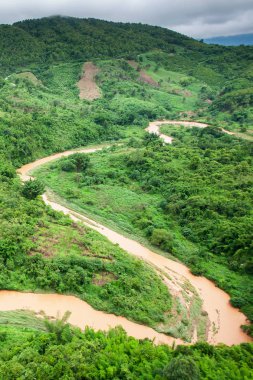 Yağmur mevsiminde taşan bir nehrin havadan görünüşü, Kuzey Tayland 'ın Nan Eyaleti sıradağları boyunca akan bir nehir..