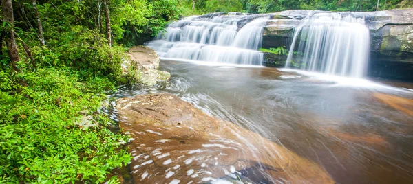 Resmedilmeye değer antik yaz sabahı şelalesi, tatlı su yüzeyinde köpükle akış sanatı, yemyeşil tropikal bitkiler ve vahşi ağaçlar. Phu Kradueng Ulusal Parkı, Tayland. Uzun pozlama.