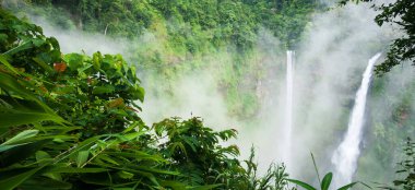 Harika Tad Fane şelalesi, sisli, pitoresk yağmur mevsiminde ikiz şelalede, Güney Laos 'ta turistik eğlence..