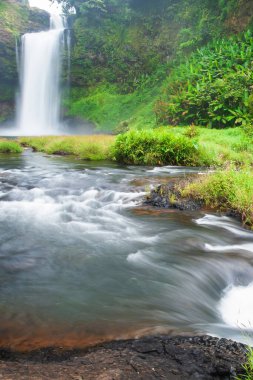 Yağmurlu bir sabahta tropikal bir şelale, tatlı su vadideki havaya sıçrıyor ve esiyor. Bolaven Platosu, Pakse, Laos. Uzun pozlama.