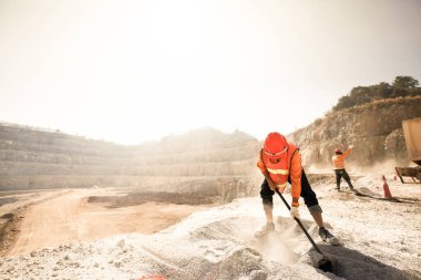 Madenciler arka planda tozlu ve kavurucu sıcak madencilik ve sıcak yaz güneşinde madencilik aletleriyle çalışıyorlar. Sıkı çalışma konsepti. Gürültü, Tahıl.