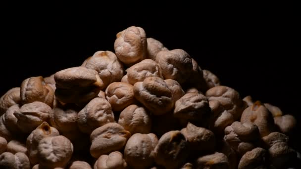 Garbanzos o garbanzos en un bol girando sobre fondo negro — Vídeo de stock