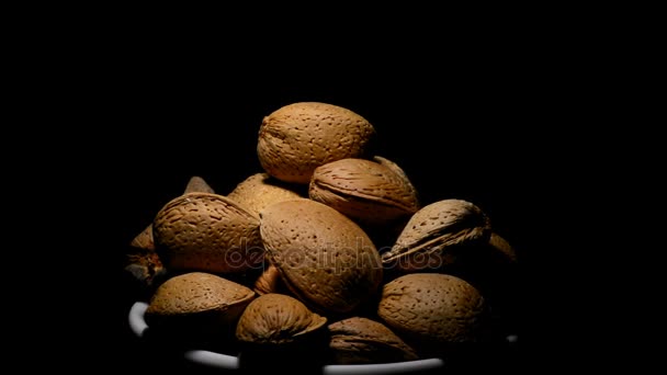 Bowl with almonds nuts in rotation on black background — Stock Video