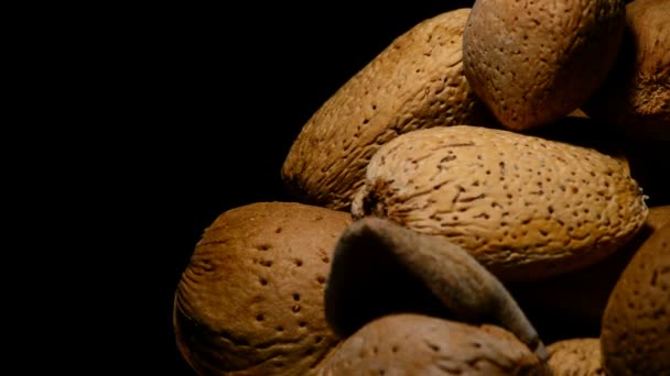 Schüssel mit Mandelnüssen in Rotation auf schwarzem Hintergrund — Stockvideo