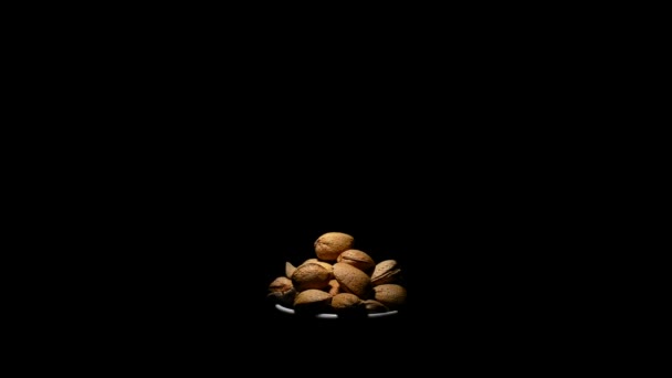 Bol aux amandes écrous en rotation sur fond noir 