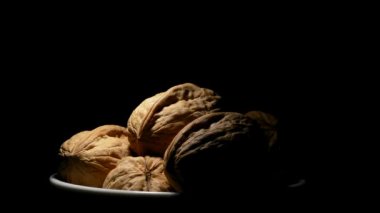 Ceviz gıda rotasyon siyah arka plan üzerine bir kase