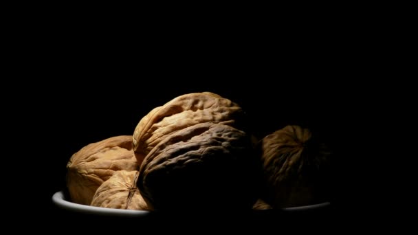 Еда из грецких орехов в миске в ротации на черном фоне — стоковое видео
