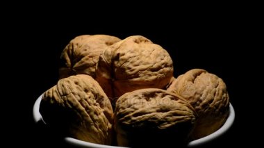 Rotasyon siyah arka plan üzerine bir kase ceviz