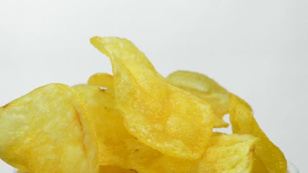 Картофельные чипсы в миске вращаются на белом фоне — стоковое видео