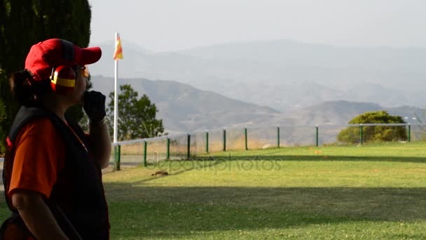 Mujer tirador skeet apuntando y disparando un rifle durante una competición — Vídeos de Stock