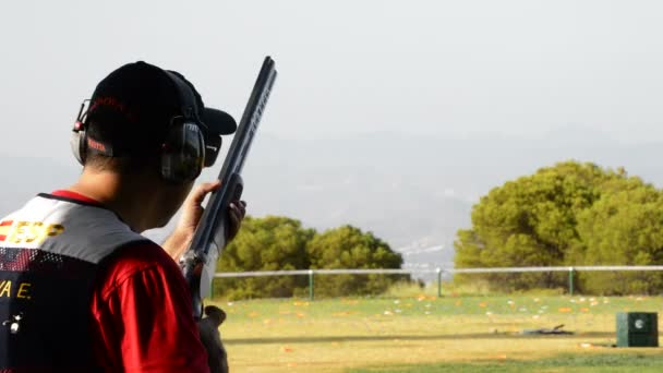 Shooter man skeet apontando e disparando um rifle em uma competição de skeet — Vídeo de Stock