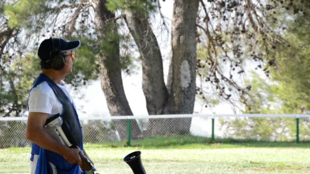 Skeet tirador hombre apuntando y disparando un rifle durante una competición — Vídeos de Stock