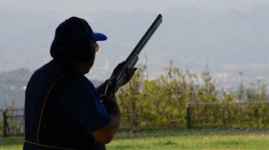 Tetikçi adam skeet bir tüfek ateş